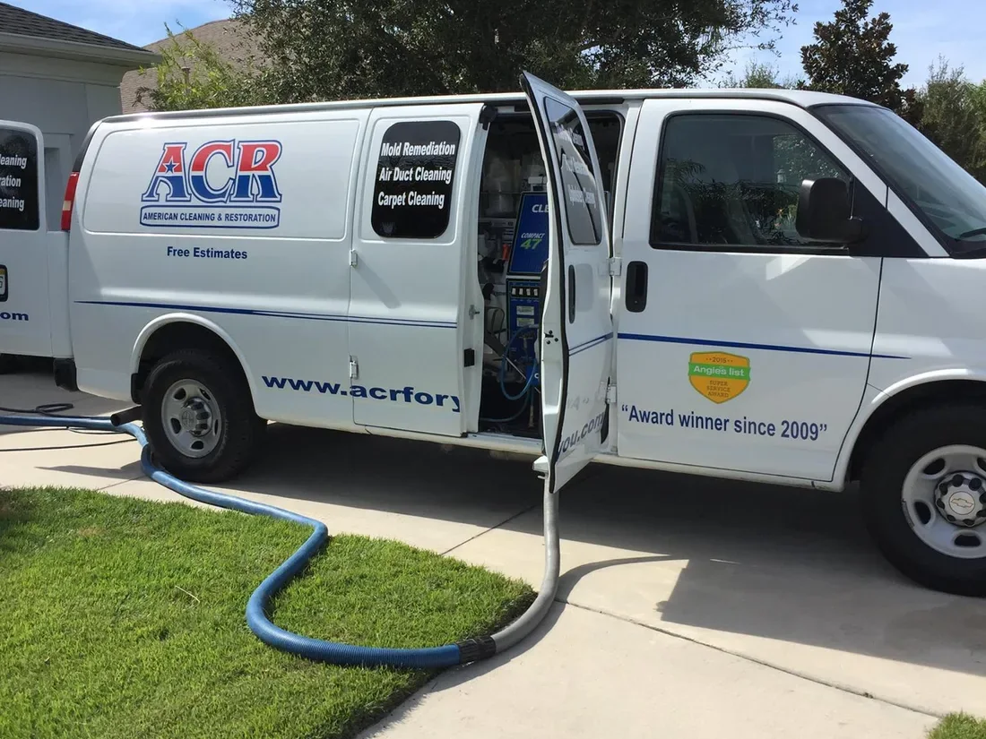 ACR van with a duct cleaning hose run across the lawn to the house mid-job