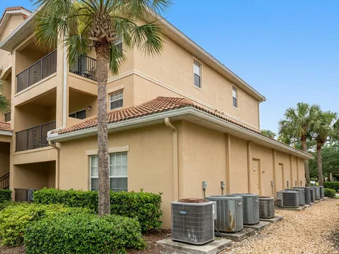 Three-story apartment building with a row of AC condensers along the side